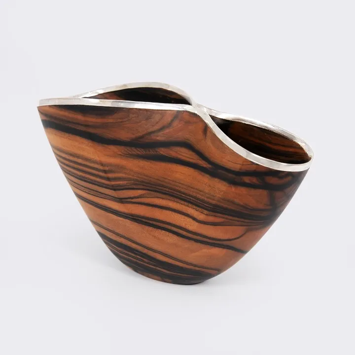 Handcrafted wood centerpiece with an organic wave shape and polished silver rim, luxury artisan design from Laos.