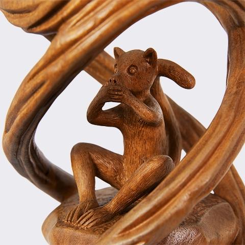 Macro detail of the 'Speak No Evil' figure in a complex wooden sculpture, highlighting the master artisan carving technique.