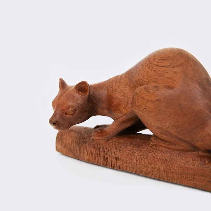 Handcrafted exotic wood sculpture of a stalking Fossa, a rare collectible wildlife art piece made in Madagascar.