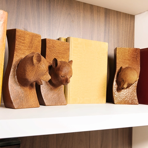 Luxury library decoration: a set of lemur sculptures elegantly placed on a modern shelf.