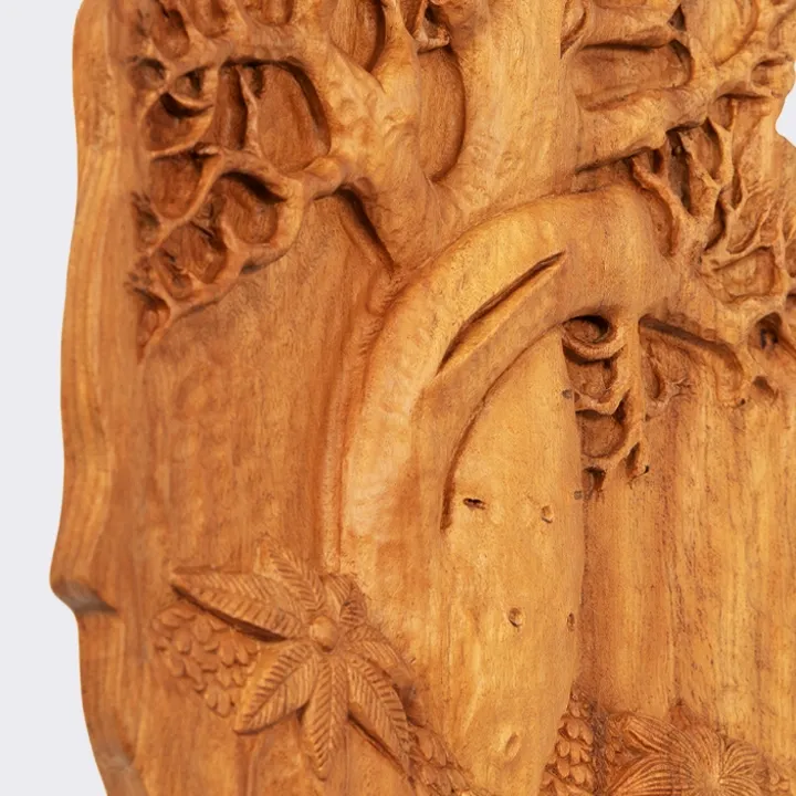 Macro detail of a hand-carved wooden bas-relief showing the intertwined trunks of the 