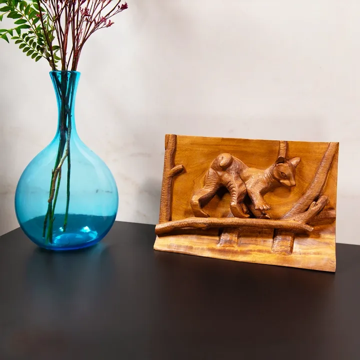 Authentic wildlife art from Madagascar: Handcrafted wood bas-relief panel depicting a Fossa cub walking on a tree branch.