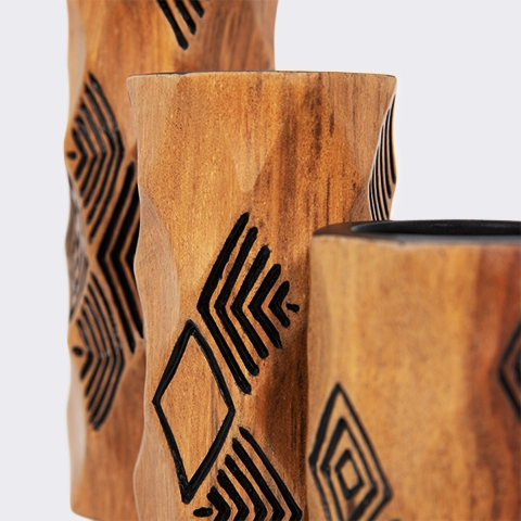 Close-up of a wooden candlestick, showing hand-carved geometric lines highlighting the fine craftsmanship and smooth finish