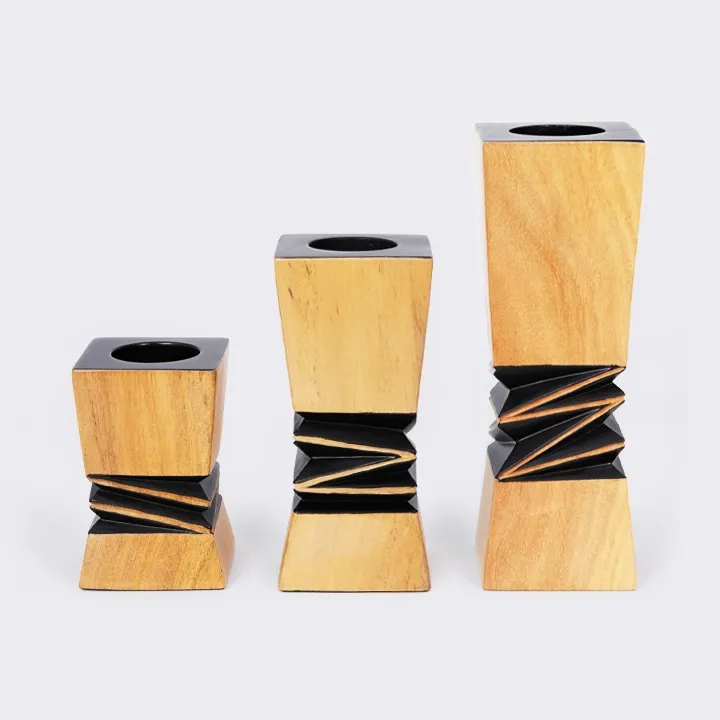 Set of handcrafted architectural wooden in various sizes, candlestick with a contrasting black geometric relief in the center.