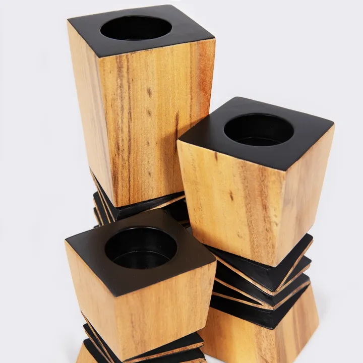 Handcrafted architectural wooden candlestick with a contrasting black geometric relief in the center.
