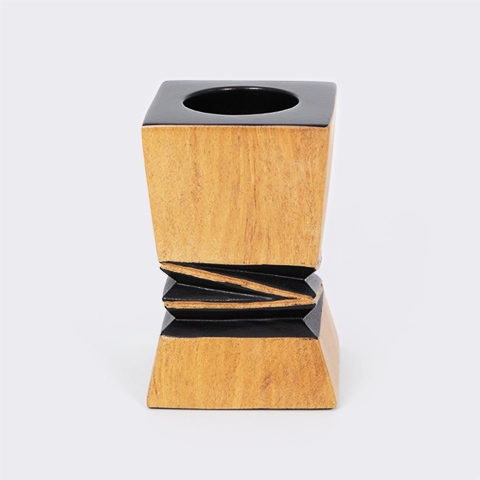 Handcrafted architectural wooden candlestick with a contrasting black geometric relief in the center.