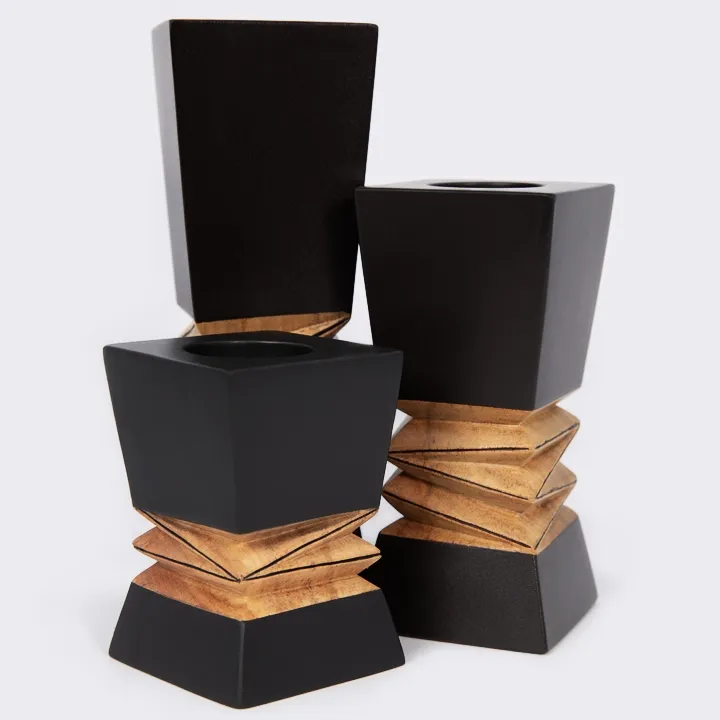 Close-up detail of the 'Tsara' candle holder, showing the central hand-carved zig-zag wood pattern contrasting with the smooth black finish