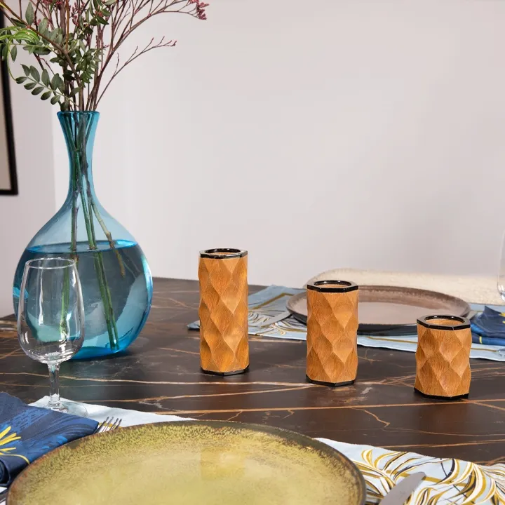 Handcrafted wooden candlestick with a contemporary black finish and tribal-inspired wavy carvings.