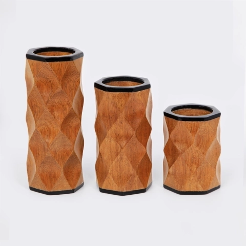 Handcrafted wooden candlestick with a contemporary black finish and tribal-inspired wavy carvings.
