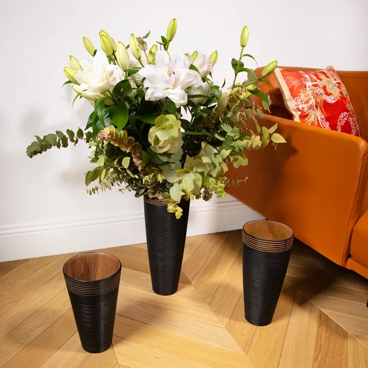 Conical wooden vase, handcrafted, with a matte black finish and sculpted horizontal ribs.