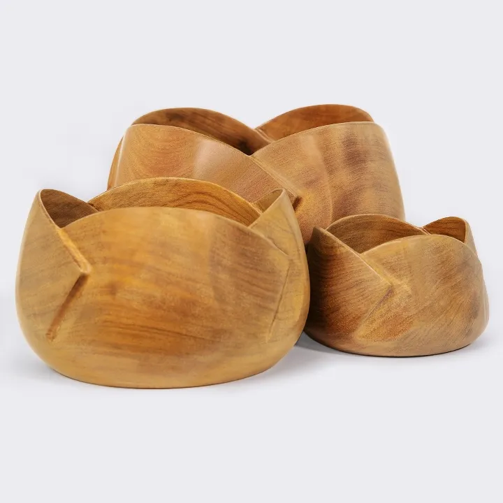 Set of three handcrafted nesting sohihy wood bowls with a blooming flower silhouette.
