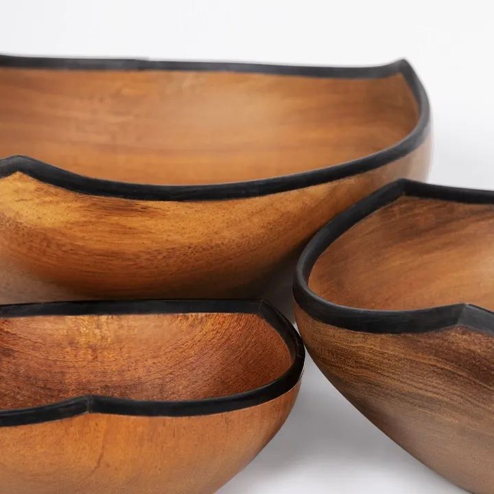 Rotating view of the  Trio of handcrafted wooden serving bowls with a sculptural water lily shape and contrasting horn rim.