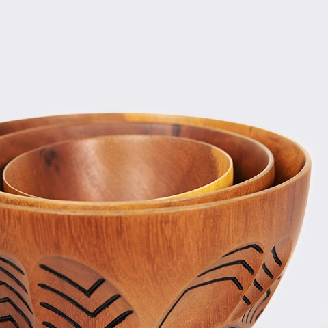 Close-up detail of the 'Soa' wooden bowl, featuring hand-carved abstract leaf patterns with black ink accents.