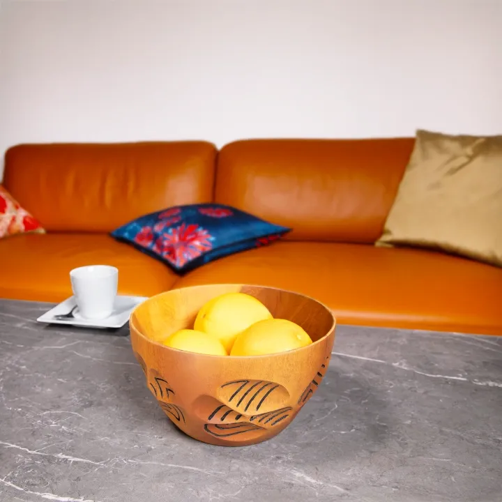 Modern living room decor: Handcrafted round wooden bowl displayed on a grey marble table.