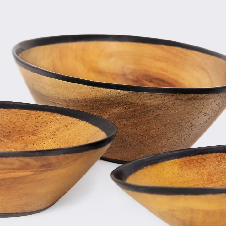 Close-up of the 'Oria' smooth wooden bowl, highlighting the polished natural grain and minimalist black rim.