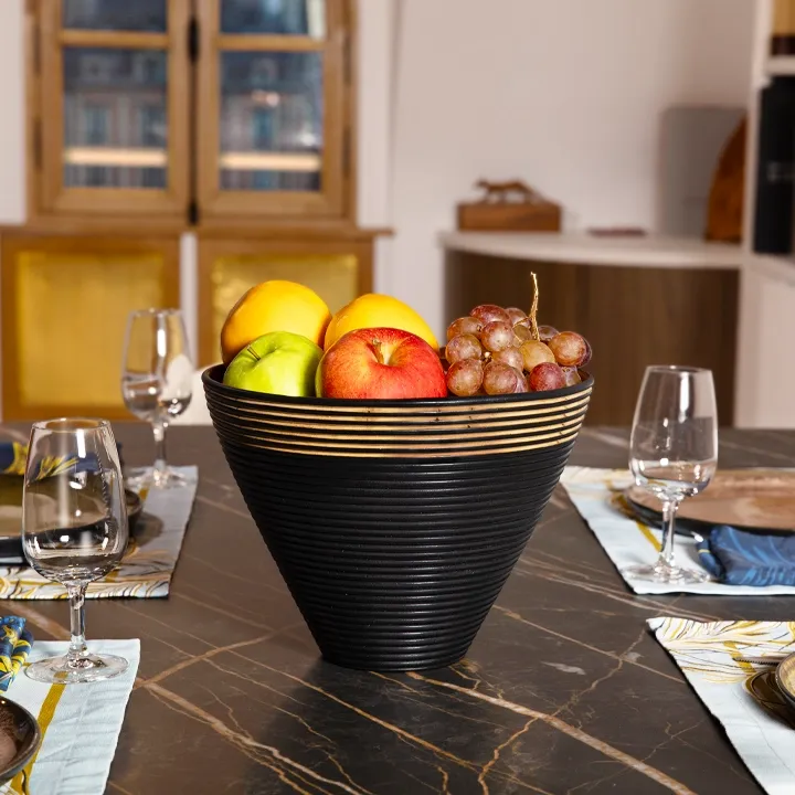 Handcrafted conical bowl in natural wood, with a matte black ribbed exterior and a natural gold interior.